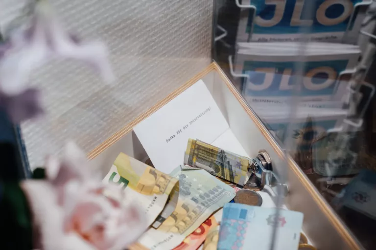 Spendenbox mit Dankeskärtchen und Geld
